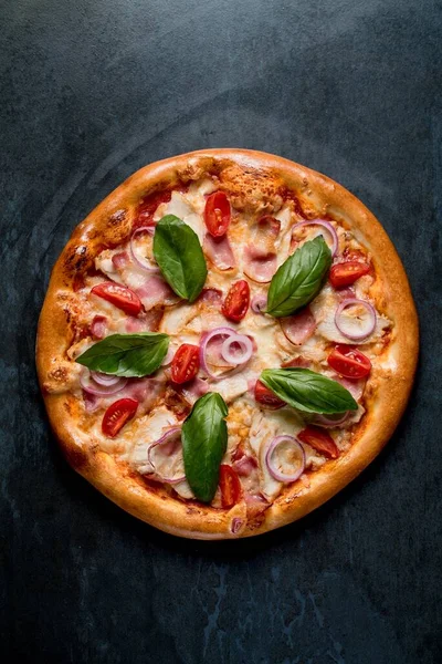 İtalyan pizzası, domuz pastırması, fesleğen, siyah arka plan manzaralı.