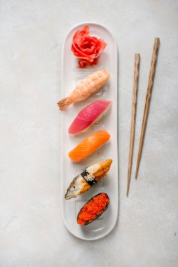 Suşi dürümlü tabak somon balığı, ton balığı zencefilli ve taş desenli güpegündüz kafe restoranına yapışmış.