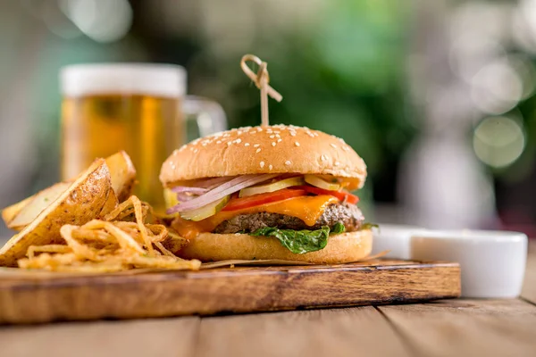 Biftek peynirli burger fesleğen soğan soslu patates ızgara soğan birası kağıt tahta tahta tahta tahta tahta tahta tahta tahta tahta ahşap kafe restoran terası bokeh
