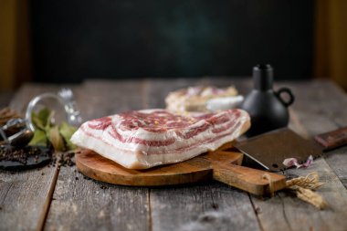 Tahta tahtada baharatlı tuzlu göğüs eti ve sarımsaklı biber kavanozu ahşap doku.