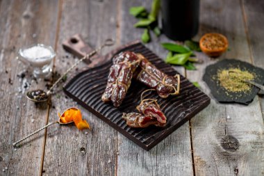 Ahşap tahtada kurutulmuş et ve lezzetli limon baharatları tuz yaprağı.