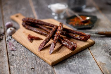 Ahşap tahtada salam ve sarımsaklı baharat kaşığı bıçağı.