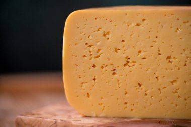 Orta sert peynir gouda edam tahtanın üzerinde güneş ışığı masasının üzerinde geleneksel masa dokusu manzarası