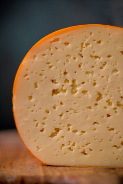 Orta sert peynir gouda edam tahtanın üzerinde güneş ışığı masasının üzerinde geleneksel masa dokusu manzarası