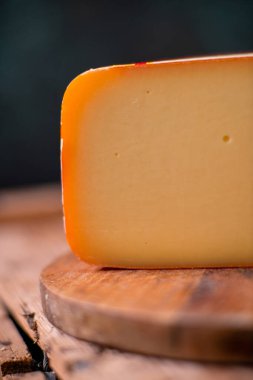 Tahtada parmesan peyniri, güneş ışığı masasında geleneksel masa dokusu, yan görünüş.