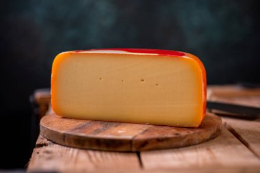 Tahtada parmesan peyniri, güneş ışığı masasında geleneksel masa dokusu, yan görünüş.