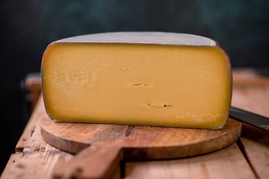 Tahtada parmesan peyniri, güneş ışığı masasında geleneksel masa dokusu, yan görünüş.