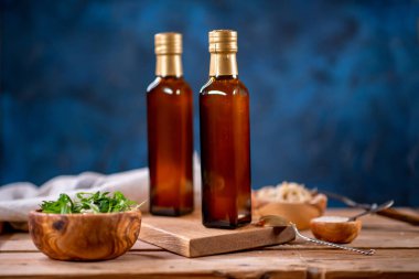 İki şişe zeytinyağı, bir kase zeytin ve ahşap tahta kenarlı salata.