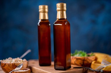 İki şişe zeytinyağı, bir kase zeytin ve ahşap tahta kenarlı salata.