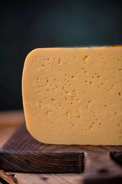 Orta sert peynir gouda edam tahtanın üzerinde güneş ışığı masasının üzerinde geleneksel masa dokusu manzarası