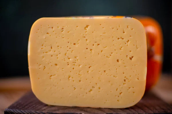 Orta sert peynir gouda edam tahtanın üzerinde güneş ışığı masasının üzerinde geleneksel masa dokusu manzarası