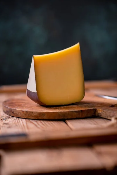 Tahtada parmesan peyniri, güneş ışığı masasında geleneksel masa dokusu, yan görünüş.
