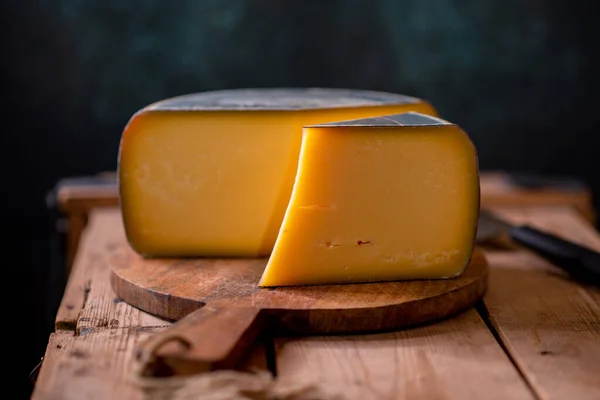 Tahtada parmesan peyniri, güneş ışığı masasında geleneksel masa dokusu, yan görünüş.