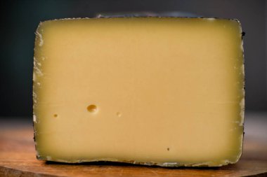 Orta boy sert peynirli gouda edam, tahta tahtada. Bıçak ahşap desenli, gündüz görüşlü.