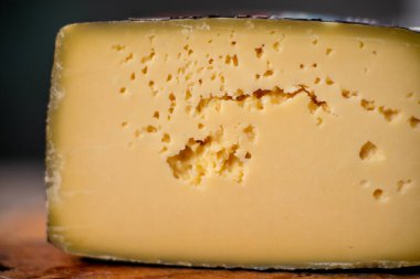 Orta boy sert peynirli gouda edam, tahta tahtada. Bıçak ahşap desenli, gündüz görüşlü.