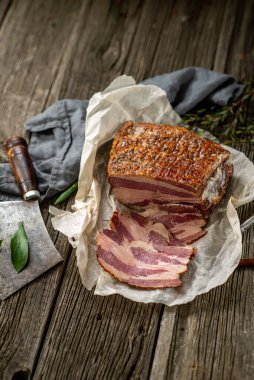 Kağıt üzerinde tuzlanmış domuz pastırması, mutfak baltası, mutfak mutfağı ahşap dokular.