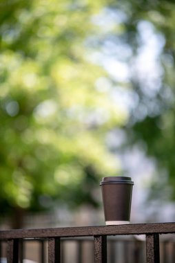 Şehir sokaklarında bir fincan kahve yaprak güneş ışığı şehir manzarası bırakır.