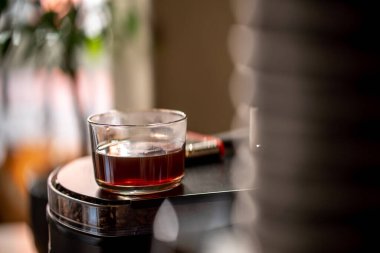 Bir bardak siyah filtre kahve. Gün ışığı kahvesi kahvehanesi manzarasına dökülüyor.