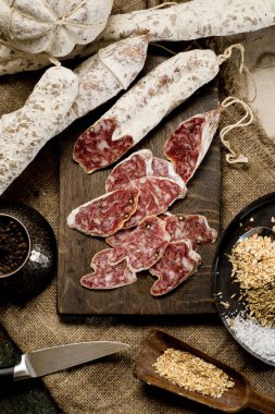 Ahşap tahtada baharatlı, sarımsaklı biber kavanozu ahşap desenli sığır eti sosisi.