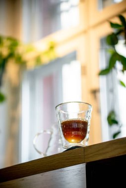 Kahve fincanının üzerindeki siyah filtre kahve fincanın kenarından dökülüyor.