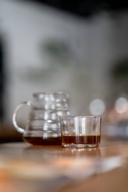 Kahve servisindeki masaya koyu filtre kahve. Sert kahve fincanın yanına dökülüyor.