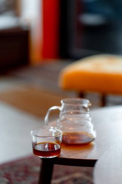 Kahve servisindeki masaya koyu filtre kahve. Sert kahve fincanın yanına dökülüyor.