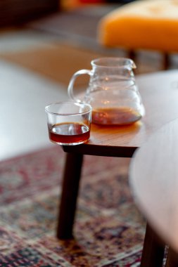 Kahve servisindeki masaya koyu filtre kahve. Sert kahve fincanın yanına dökülüyor.