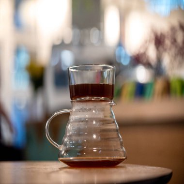 Kahve servisindeki masaya koyu filtre kahve. Sert kahve fincanın yanına dökülüyor.