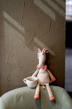 Kahvehanedeki sandalyede bir fincan siyah filtreli kahve. Yan manzaranın üzerine dökülüyor.