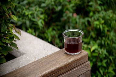 Kafe teras bahçesindeki filtre kahvenin üzerine koyu kahve dökülen fincan şehir manzarasını terk eder.