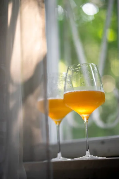 窓にクラフトビールが付いているガラス日光日没の朝の葉側の景色 — ストック写真