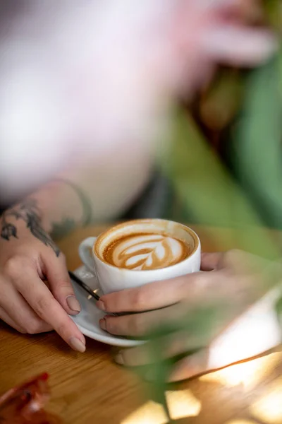 Kahve Dükkanında Kapuçinosu Olan Bir Kız Kafeterya Çiçekleri Masa Ahşap — Stok fotoğraf