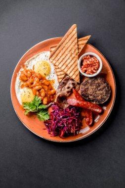 Geleneksel kahvaltıda yumurtalı tost ızgara pirzola soslu sosis fasulye salatası.