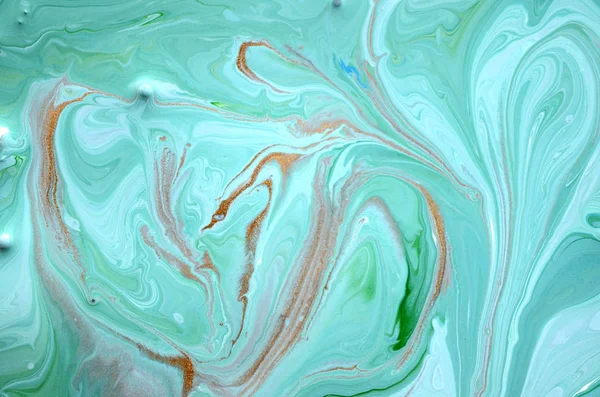 Liquid uneven blue and green marbling pattern with golden glitter and glare of light.