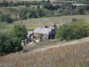 Tarlaların, sebze bahçelerinin ve ağaçların olduğu eski köy evi.