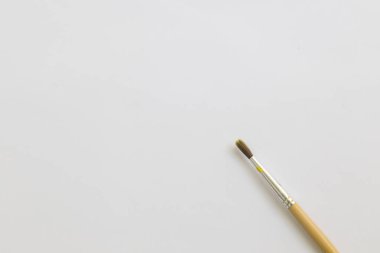 Çalışma alanı ile beyaz kağıt üzerinde boya fırçası.