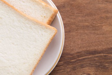 Ahşap arka plan üzerinde plaka ekmek dilimlenmiş.