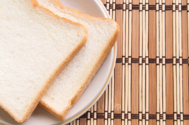 Ahşap arka plan üzerinde plaka ekmek dilimlenmiş.