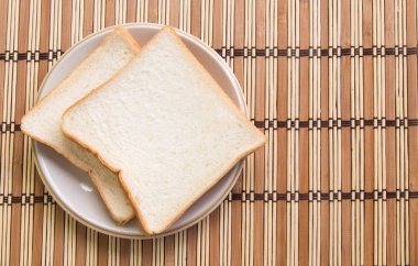 Ahşap arka plan üzerinde plaka ekmek dilimlenmiş.