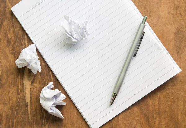 Crumple papel blanco y pluma con cuaderno en el escritorio de madera . — Foto de Stock