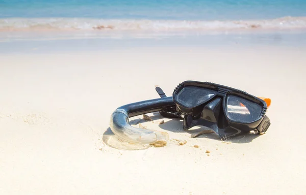Masker en snorkel in de branding op het zandstrand. — Stockfoto