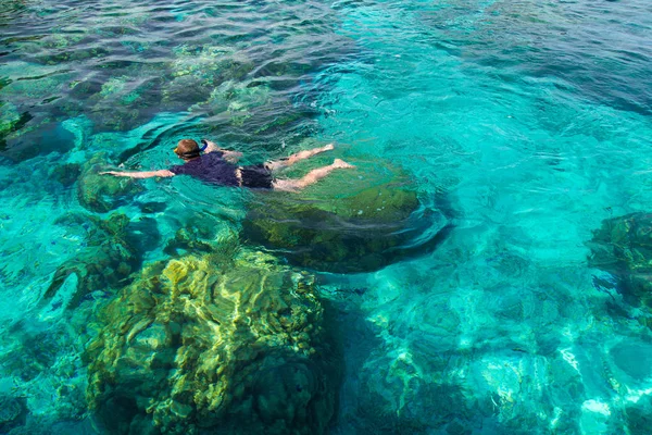 Junger Mann schnorchelt über Korallenriff im transparenten tropischen Meer, rok island, thailand. — Stockfoto