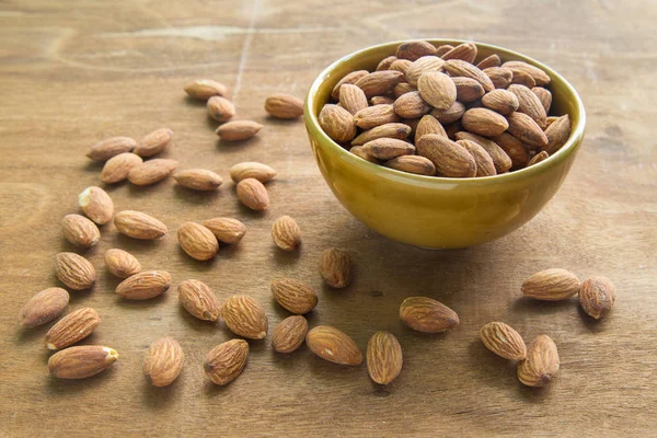 Almendras en tazón sobre fondo de madera, se centran en las almendras en tazón . — Foto de Stock