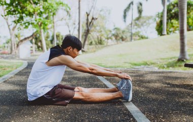 Genç adam organları, germe genel Park'ta jogging için Isınma.