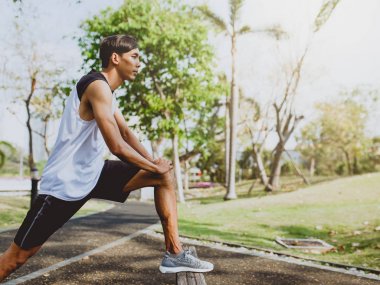 Genç adam organları, germe genel Park'ta jogging için Isınma.