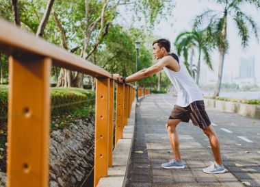 Genç adam organları, germe genel Park'ta jogging için Isınma.