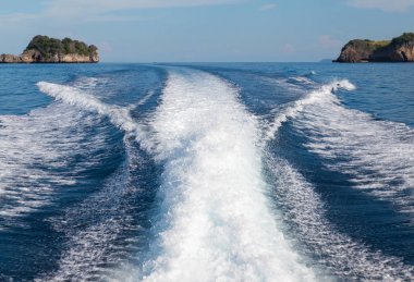 Bir yüksek hızlı tekne ve Adası arka plan dalgalar.