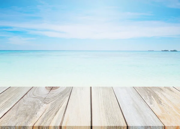 Holz Tischplatte und verschwimmen Hintergrund des Strandes. — Stockfoto