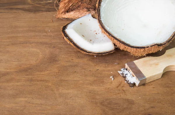 Kokos- und Kokosreibe auf Holzgrund. — Stockfoto