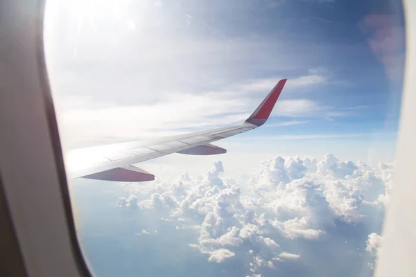 Aile d'un avion volant au-dessus du ciel bleu et des nuages . — Photo